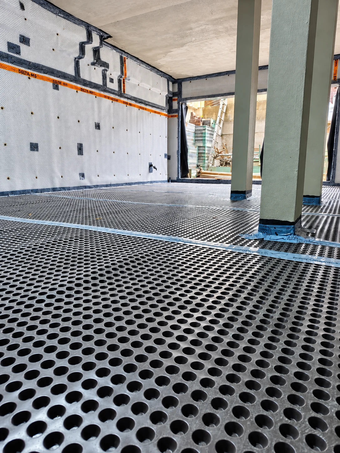 Wide view of an LNK Delta Type C waterproofing installation across a below-ground space